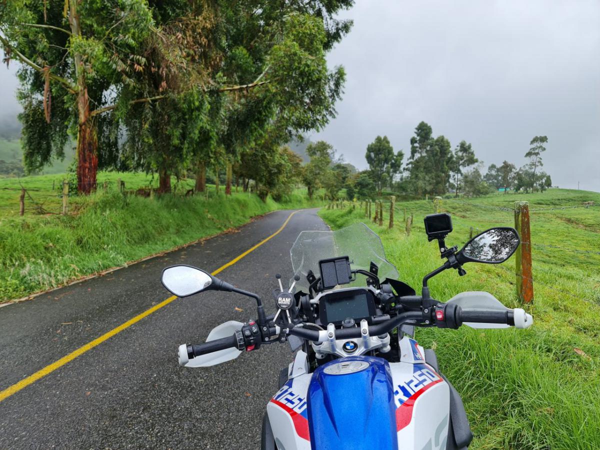  /></a></p><p>E OK, Cristian! Suntem antrenați, știm teorie, ba chiar și practică, am avut profesori buni prin coclaurile prin care am mai mers înainte de Columbia. Motocicleta e pe modul Enduro pentru a limita intervenția controlului tracțiunii. Căci am nevoie de tracțiune, nu? Accelerez lin, dar roata se învârte complet în gol și computerul taie gazul. OK, nu-i bai. Dezactivez complet controlul tracțiunii, că doar nu o prinde brusc și m-o arunca prin copaci. O prostie, evident. Roata se învârte în voie și în loc să prindă aderență și să scoată motocicleta din groapă, mișcarea adâncește groapa. Atât de rău încât acum pot să cobor din șa și motocicleta stă singură în „picioare”. Nu-i bine!</p><p>Nu-i bine pentru că de când am urcat spre junglă n-am văzut țipenie de om. Și pentru că… e junglă, bade! Adică nu sunt pe DN1 între Comarnic și Sinaia, în sensul ăsta. Plouă de rupe, nu trece nimeni, mâncare și apă nu am, iar forța mea fizică este complet insuficientă pentru a scoate motocicleta din groapă. Ce pot să fac? Nimic, evident. Mă trag mai hăis, într-o parte în care copacii mai liniștesc din căderea violentă a ploii, și aștept. Zece minute, douăzeci de minute, jumătate de oră. Hmmm… Oare e momentul să apelăm la ultima soluție? Adică să încerc să răstorn motocicleta pe o parte și să o târăsc, apucând de ce găsesc, până iese din groapă? În teorie ar merge, în practică n-aș vrea să produc daune importante decât atunci când e cu adevărat o situație la limită, fără altă scăpare.</p><p>Și cum analizez eu toate opțiunile astea, iată sunetul salvator. Sub forma unui zgomot de motor de 4×4. Roșu, vechi, ca-n cele mai violente filme cu traficanți pe care le-ați văzut în viața voastră. Nu apuc să mă văd împușcat în cap că mă liniștesc. La volan e un nene cu o figură pașnică. Oprește imediat, încercăm să discutăm despre problemă cu puțina spaniolă cu care m-a binecuvântat pe mine serialul Înger Sălbatic cu Natalia Oreiro, și ajungem la concluzia că nu se poate să ne facă pe noi, doi bărbați în puterea vârstei, o motocicletă. Ne apucăm și tragem de ea, tâșnește transpirația din noi precum zeama din pepenele scăpat pe gresia supermarketului, dar degeaba. Eu când vă zic că s-a înfipt? Îl văd cum mustăcește, cum calculează, cum mormăie, și îmi dau seama că urmează să sugereze fix ceea ce voiam eu ca ultimă variantă. Hai s-o răsturnăm și să o tragem pe o parte. Se face praf, rupem ceva sigur de pe ea, dar măcar o scoatem.</p><p>Ce să-i zic? Că vreau și scăpat de problemă, dar și fără daune? N-am cum, că poate se supără, pleacă, și mă lasă iar singur în junglă să o iau razna și să vorbesc cu motocicleta precum Tom Hanks în Naufragiatul. Facem așa, tată! Dar înainte să rașchetăm bunătate de inginerie nemțească pe pământul pietros strămoșesc columbian, hai să mai încercăm o singură dată să o împingem în față, să iasă fără daune. Aprobă și încercăm. Oameni buni, nu vreau să spun că îmi imaginez durerile nașterii, dar cred că am fost pe aproape. Împing cu atât de multă forță încât simt cum mi se subțiază fibrele de mușchi de pe coapse. Îmi țin respirația, mă proptesc într-o altă groapă mai mică și împing ca și cum viața mea ar depinde de asta. Și, ce să vezi, motocicleta se mișcă, prindem o pârghie favorabilă și o scoatem. Omul nostru e la fel de fericit ca mine, chiar am muncit. N-am un pesos la mine să-i dau, că merită, dar îi mulțumesc chiar și în spaniolă, grație învățăturilor Nataliei.</p><p><a href=